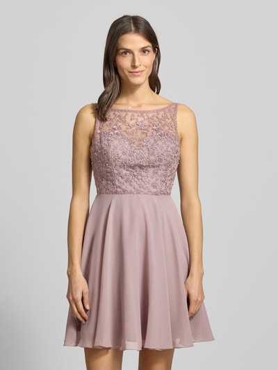 Frauenmodel trägt Regular fit Minikleid mit floralem Spitzenbesatz von Laona in semitransparentem Design, Ziersteinbesatz, ärmellos, blickdichter Unterrock, Flieder-Farbe; Ganzkörperansicht von vorne.