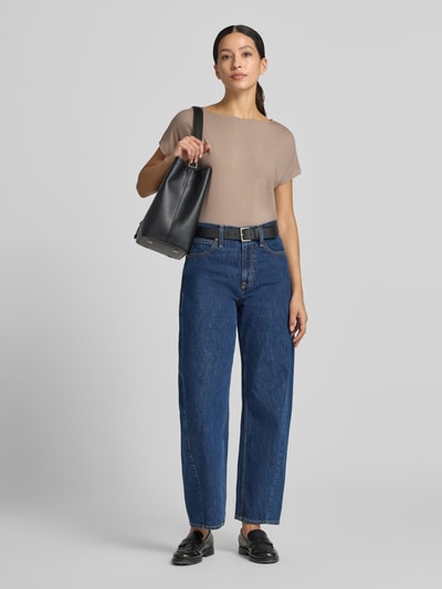 Frauenmodel trägt Oversized T-Shirt aus Viskose-Mix von s.Oliver RED LABEL in Beige, kombiniert mit blauer Jeans, Ganzkörperansicht von vorne.
