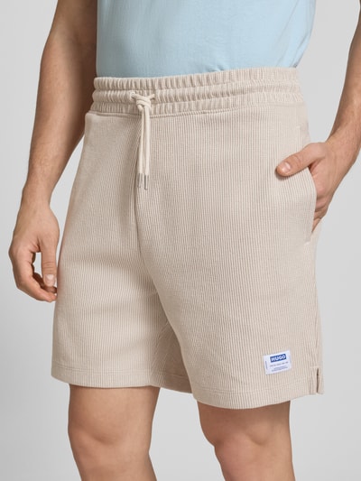 Männermodel trägt Regular Fit Sweatshorts aus Baumwoll-Mix Modell 'NUWAFFLO' von HUGO, Optik: Unifarben, Nahaufnahme Oberkörper.