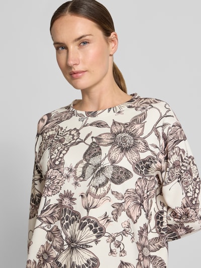 Frauenmodel trägt Regular Fit Bluse aus Viskose-Mix von monari, floraler Allover-Print in Beige und Braun, Nahaufnahme Oberkörper.