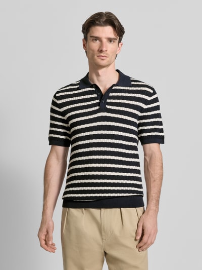 Männermodel trägt Poloshirt mit Polokragen und kurzer Knopfleiste von MCNEAL, schwarz-weiße Streifen, reine Baumwolle, Regular Fit, Ganzkörperansicht von vorne.