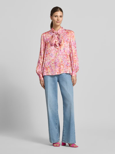 Modelka nosi Relaxed Fit Hemdbluse aus reiner Viskose od Rich & Royal, różowy wzór kwiatowy, długie rękawy, widok całej sylwetki z przodu.