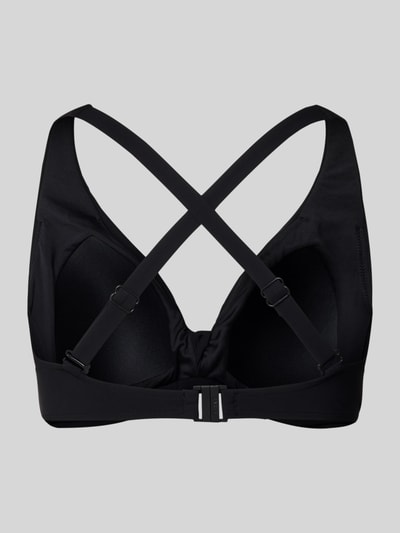 Frauenmodel trägt Bikini-Oberteil mit Knotendetail Modell 'SOLID' von Barts in Schwarz, Material-Mix mit Stretch-Anteil, Ganzkörperansicht Rückansicht.