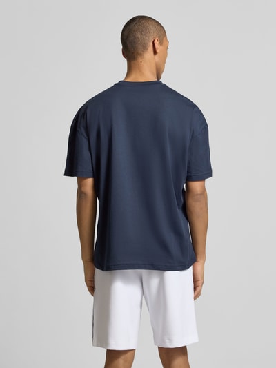 Männermodel trägt Herren T-Shirt mit Logo und Rundhalsausschnitt von EA7 Emporio Armani in Navy, Reine Baumwolle, Regular-Fit, Ganzkörperansicht Rückansicht. Rückenlänge bei Größe M: 68 cm.