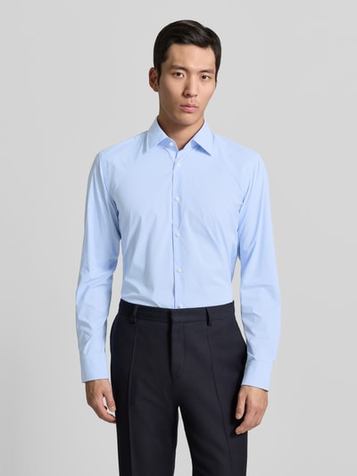 Männermodel trägt Regular Fit Businesshemd mit Kombimanschette Modell 'P-JOE-K' von BOSS, hellblau, Gitterkaro, Kentkragen, Ganzkörperansicht von vorne.