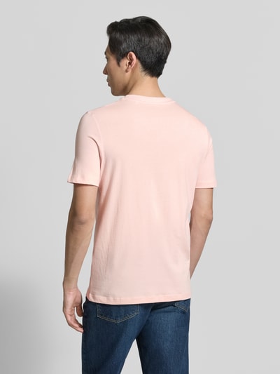 Männermodel trägt Regular Fit T-Shirt aus reiner Baumwolle von s.Oliver RED LABEL, Optik: Unifarben, Label-Print, Ganzkörperansicht Rückansicht.