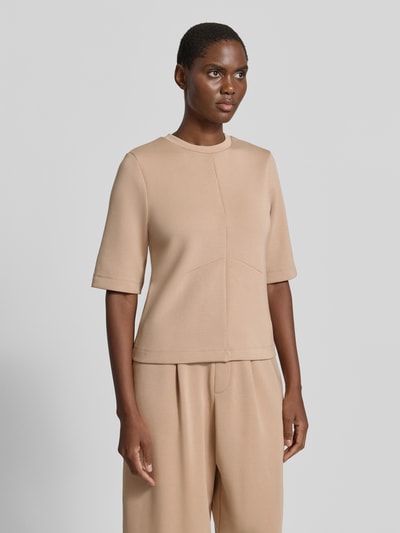 Modelka nosi Regular Fit Sweatshirt mit Ziernähten von Christian Berg Woman, elastyczna mieszanka materiałów z modalem, ozdobne szwy, okrągły dekolt, rękaw o dł. 1/2, beżowy kolor, gładka tekstura, widok całej sylwetki z przodu.