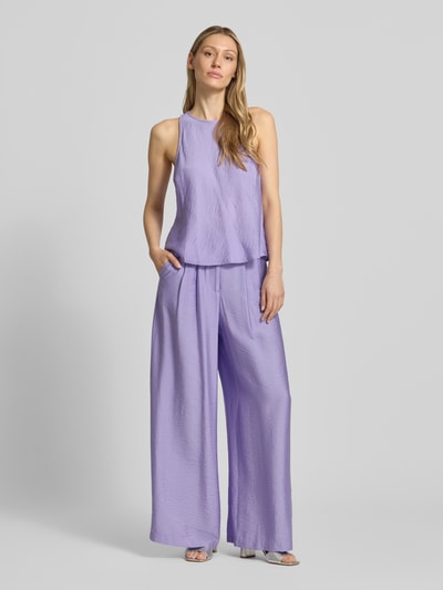 Frauenmodel trägt Wide Fit Stoffhose aus Viskose-Mix Modell 'Finja' von GUIDO MARIA KRETSCHMER WOMAN in Flieder mit Bundfalten, Ganzkörperansicht von vorne.