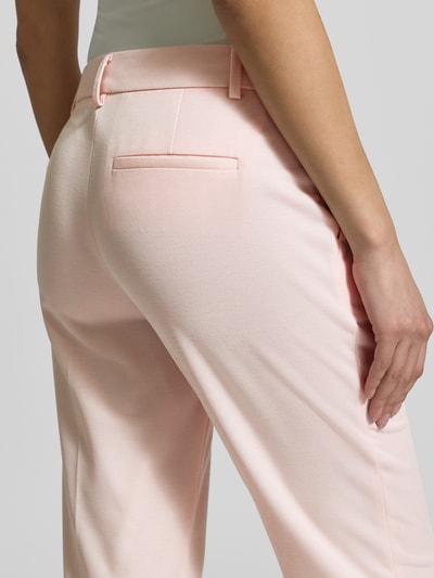 Frauenmodel trägt Hose mit Bügelfalten von Christian Berg Woman Selection in zartem Rosa, glatte Stoffstruktur, Detailaufnahme Rückansicht, Material-Mix mit Viskose-Anteil, Regular Fit, Bügelfalten, Gesäßtasche.