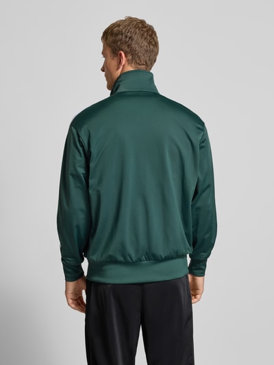 Männermodel draagt Regular Fit Sweatjacke met Stehkragen Model 'Bird' van adidas Originals, donkergroen, elastische materiaalmix, gestikt logo, steekzakken met ritssluiting, elastische boorden, ruglengte maat M 72 cm, mouwlengte 66 cm, ganzkörperansicht rückansicht.