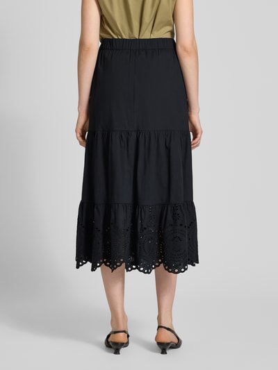 Frauenmodel trägt Midirock mit Lochstitching von Christian Berg Woman Selection in Schwarz, leichte A-Linie, Rückansicht Ganzkörperansicht.
