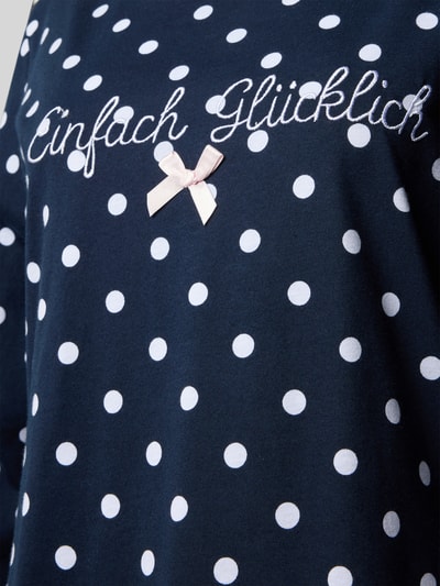 Vrouwenmodel draagt Nachthemd im Allover-Look mit Stitching van LOUIS & LOUISA in donkerblauw met witte stippen, puur katoen, all-over look, ronde hals, detailopname bovenlichaam.