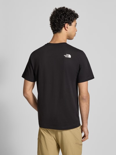 Mannenmodel draagt Regular Fit T-Shirt met Logo-Print van The North Face in zwart, katoenmix, ronde hals, ruglengte 70 cm, achteraanzicht.