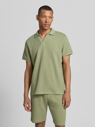 Męski model nosi Regular Fit Strick-Poloshirt mit V-Ausschnitt von MCNEAL, mieszanka bawełny z dodatkiem streczu, krój regular fit, dekolt w serek, długość tyłu w rozmiarze M: 70 cm, jasna zieleń, prążkowana faktura, gładkie rękawy, całkowity widok z przodu