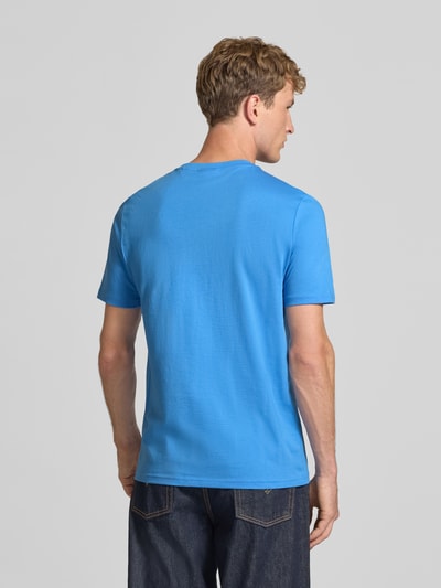 Männermodel trägt Regular Fit T-Shirt aus reiner Baumwolle Modell 'Nesptee' von HUGO in kräftigem Blau, Ganzkörperansicht Rückansicht, Herren T-Shirt von HUGO Blue.