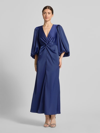 Vrouwenmodel draagt maxi-jurk met ballonmouwen van materiaalmix met stretch, getailleerd model, V-hals, knoopdetail, model 'THEA' van YAS, donkerblauw, gladde textuur, borstwijdte 32 cm, ruglengte 35 cm, mouwlengte 49 cm, volledig zicht van voren.