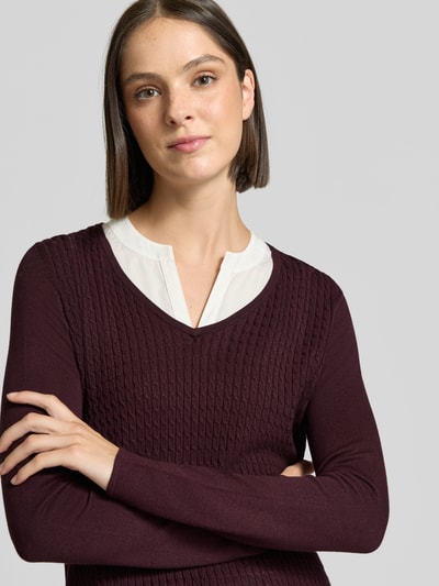 Frauenmodel trägt Longsleeve aus Viskose-Mix in Strick-Optik von COMMA, bordeaux mit Kontrast-Details, Nahaufnahme Oberkörper.