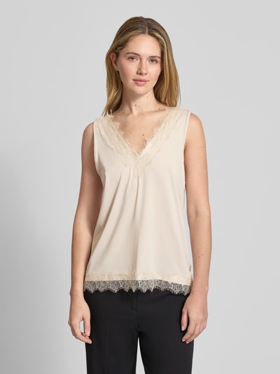 Frauenmodel trägt Trägertop aus Satin mit Spitzenbesatz Modell 'Bicco' von FREE/QUENT in Creme, Regular-Fit, V-Ausschnitt, Nahaufnahme Oberkörper. Damen Trägertop, Rückenlänge bei Größe S 43 cm, glatte Satinstruktur mit zarten Spitzen-Details.