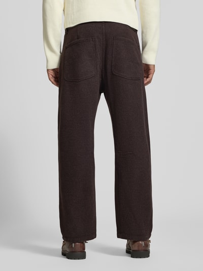 Männermodel trägt Straight Fit Stoffhose aus Baumwoll-Mix Modell 'GONAGO' von DRYKORN in Dunkelbraun, strukturierte Oberfläche, Ganzkörperansicht Rückansicht. Bundweite 45 cm, Innenbeinlänge 69 cm, elastisches Material, sichtbare Gesäßtaschen.