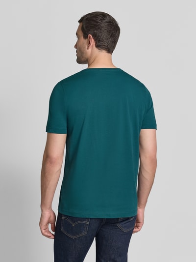 Männermodel trägt T-Shirt mit Rundhalsausschnitt und Label-Stitching von Fynch-Hatton in Smaragdgrün, glatte Baumwollstruktur, Ganzkörperansicht Rückansicht, Regular Fit, Rückenlänge bei Größe M 72 cm.
