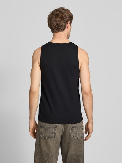 Männermodel trägt Slim Fit Tank Top aus Baumwoll-Mix von Marc O’Polo Denim in Schwarz, Rippstrick, Label Patch, Ganzkörperansicht Rückansicht.