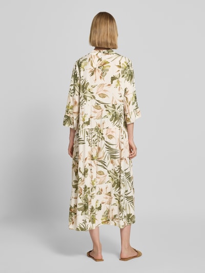 Frauenmodel trägt Midikleid aus Viskose mit Serafino-Kragen Modell 'Kl44arraa' von ZABAIONE in Creme mit grünem Blumenmuster, Ganzkörperansicht Rückansicht. Gerader Schnitt, Volantsaum, halblange Ärmel, Rückenlänge 113 cm bei Größe S, reine Viskose, weiche Textur.