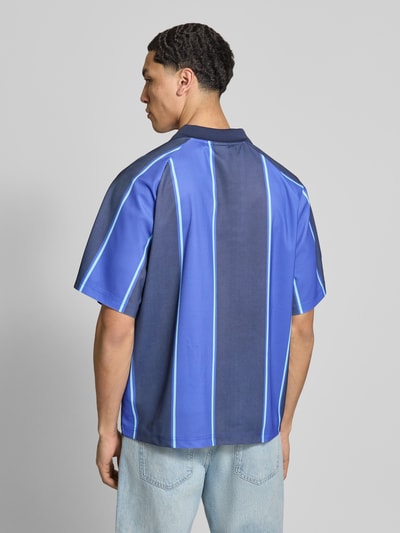 Männermodel trägt Loose Fit Poloshirt mit Motiv-Print Modell 'ZIDAN' von Only & Sons, Optik: Gestreift, Materialverarbeitung: Piqué, Ganzkörperansicht Rückansicht.
