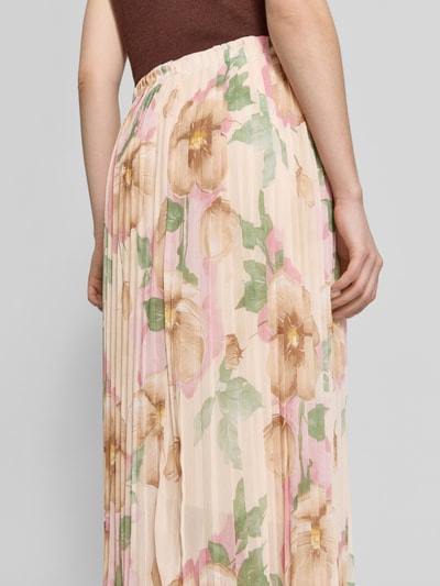 Frauenmodel trägt Midirock mit Plisseefalten Modell 'Ki44anii' von ZABAIONE im Allover-Look in Beige, Braun und Rosa, Nahaufnahme Rückansicht. Bundweite bei Größe S: 35 cm, Gesamtlänge bei Größe S: 74 cm.