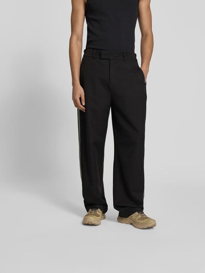 Männermodel trägt Oversized Sweatpants aus Leinen-Mix von Don't Waste Culture in Schwarz, lockerer Schnitt, sichtbarer Haken- und Reißverschluss, Hose besitzt Gesäßtaschen, strukturierte Textur, Ganzkörperansicht von vorne.
