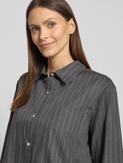 Frauenmodel trägt Regular Fit Hemdbluse aus reiner Baumwolle von Tommy Hilfiger mit Optik:Allover-Muster, gestreift, Logo-Stitching, Flanell Webstruktur, Nahaufnahme Oberkörper.