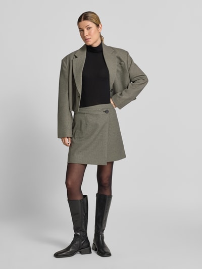 Frauenmodel trägt Longsleeve aus Lyocell-Mix mit Stehkragen von windsor, Schwarz, Slim Fit, kombiniert mit kurzem Rock und Blazer, Ganzkörperansicht von vorne. Rückenlänge bei Größe 36 beträgt 56 cm, Material mit Baumwoll-Anteil.
