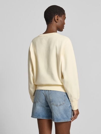 Frauenmodel trägt Relaxed Fit Sweatshirt mit Foto-Print von Anine Bing aus Reine Baumwolle in hellem Gelb, elastische Abschlüsse, Rückenlänge bei Größe S: 56 cm, Ganzkörperansicht Rückansicht.