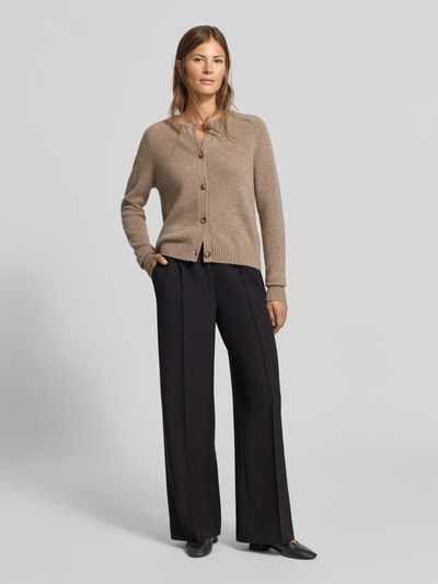 Frauenmodel trägt Wide Fit Sweatpants mit Viskose-Anteil von MYON, schwarze Farbe, Zierfalten, elastischer Mix, Ganzkörperansicht von vorne.