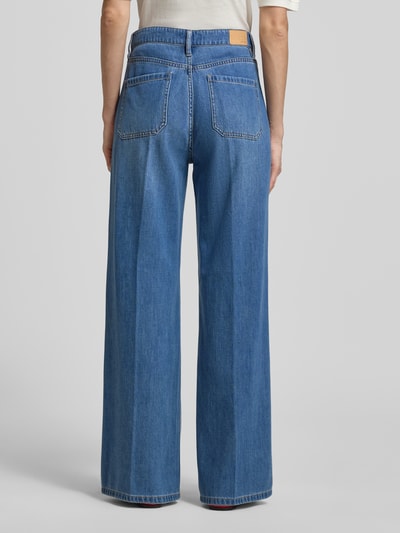 Frauenmodel trägt Regular Fit Wide Leg Jeans aus Lyocell-Baumwoll-Mix von s.Oliver BLACK LABEL in Blau mit Label Patch, Twill-Struktur, Gesäßtaschen, Bund mit Gürtelschlaufen, Ganzkörperansicht Rückansicht.