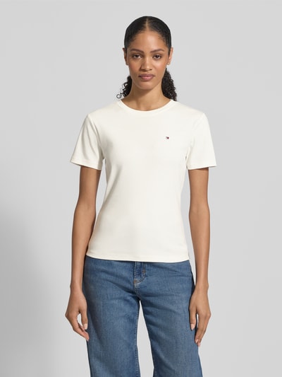 Frauenmodel trägt Slim Fit T-Shirt aus reiner Baumwolle von Tommy Hilfiger, unifarben, Logo-Stitching, Rundhals, Kurzarm, Jersey, Ganzkörperansicht von vorne.