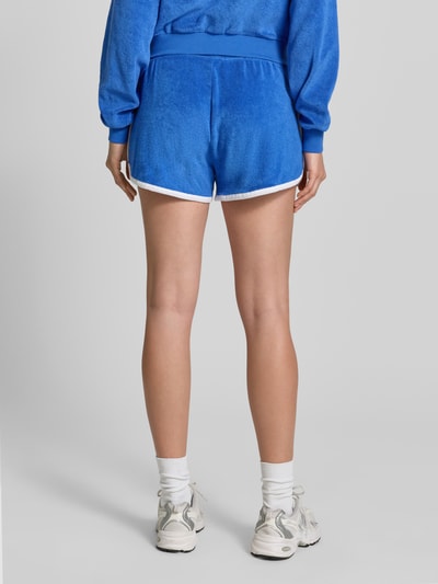 Frauenmodel trägt Regular Fit Sweatshorts aus Baumwoll-Mix von Polo Ralph Lauren in Two Tone Optik mit elastischem Bund und Eingrifftaschen, Frottee-Textur, Logo-Stitching, Ganzkörperansicht Rückansicht.