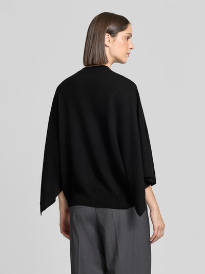 Frauenmodel trägt Relaxed Fit Pullover aus reinem Kaschmir in Strick-Optik von HERZENS in Schwarz, Rückenansicht, Ganzkörperansicht Rückansicht.