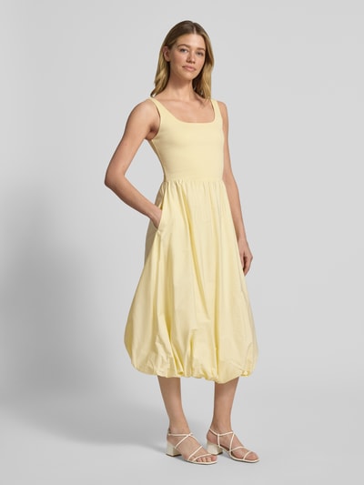 Frauenmodel trägt knielanges Bubble Kleid mit Karree-Ausschnitt von Rich & Royal, A-Linie, fein gerippt, hellgelb, Ganzkörperansicht von vorne.