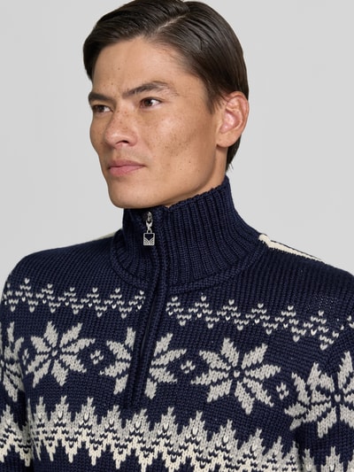 Männermodel trägt Slim Fit pullover van wolmix Model 'Myking' van Dale of Norway, donkerblauw met witte motieven, schipperskraag, Nahaufnahme Oberkörper, Ruglengte bij maat M: 72 cm, Mouwlengte bij maat M: 69 cm.