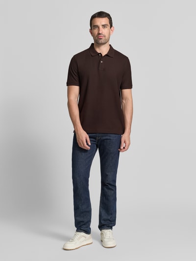 Männermodel trägt Regular Fit Poloshirt mit Label-Stitching von Fynch-Hatton in Braun, reine Baumwolle, Knopfleiste, Ganzkörperansicht von vorne.