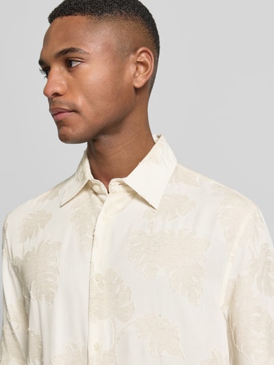 Männermodel trägt Regular Fit Freizeithemd aus Viskose-Mix Modell 'Klampo' von Matinique mit florales Allover-Design, Nahaufnahme Oberkörper.