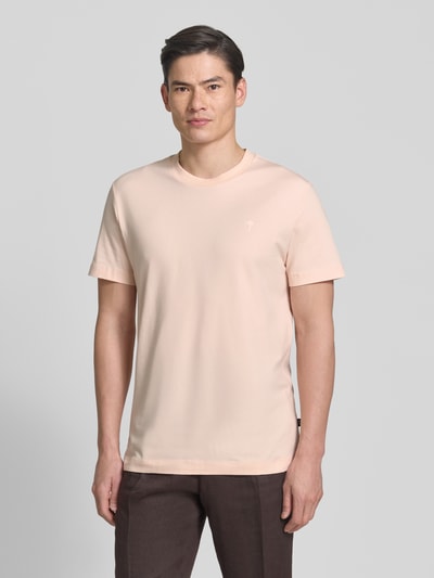 Männermodel trägt T-Shirt mit Rundhalsausschnitt Modell 'Carlonito' von JOOP! Collection, helles Rosa, glatte Struktur, Ganzkörperansicht von vorne. Baumwoll-Mix mit Stretch-Anteil, Straight Fit, Label-Detail, Rückenlänge bei Größe M 71 cm.