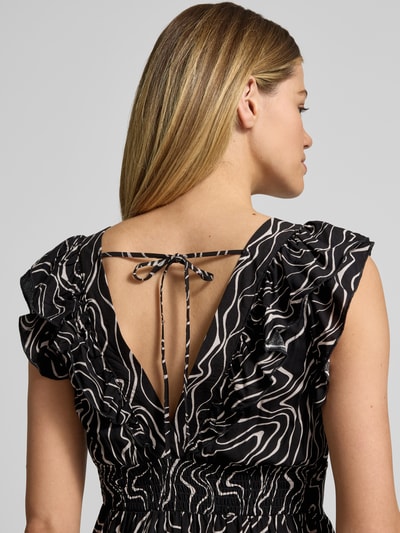Frauenmodel trägt Leicht ausgestelltes Maxikleid aus reiner Viskose Modell 'EASY JOY' von Vero Moda mit Allover-Muster und Rüschen, Nahaufnahme Rückansicht.