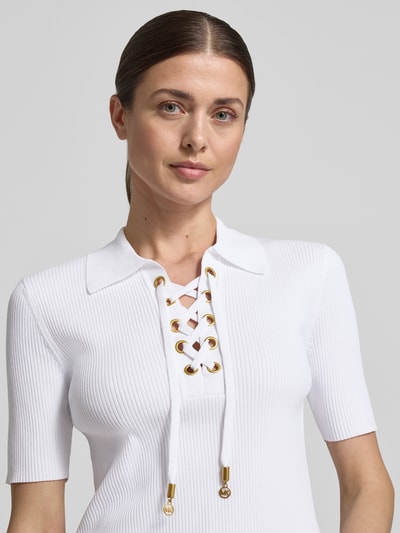 Vrouwenmodel draagt Strickshirt mit Schnürung und Umlegekragen van MICHAEL Michael Kors, viscosemix met stretch, nauwsluitend model, platte kraag, V-hals met vetersluiting, fijnrib, labeldetails, nahaufnahme bovenlichaam