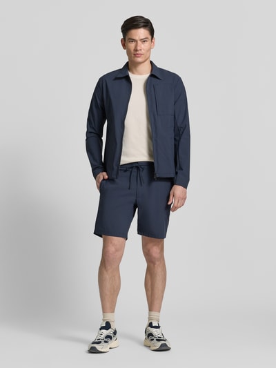 Männermodel trägt Regular Fit Jacke mit Umlegekragen Modell 'Motion' von SCANDINAVIAN EDITION, elastischer Material-Mix, marineblau, Ganzkörperansicht von vorne.