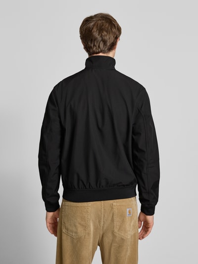Männermodel trägt schwarze Regular Fit Bomberjacke mit Stehkragen Modell 'Parker' von Jack & Jones, Softshell, Ganzkörperansicht Rückansicht