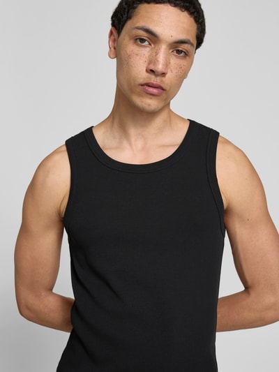 Männermodel trägt Slim Fit Top mit Rundhalsausschnitt von WON HUNDRED in Schwarz, strukturierte Baumwoll-Mix-Optik, ärmellos, Nahaufnahme Oberkörper.