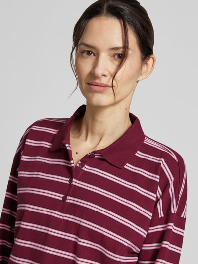 Modelka nosi Regular Fit Poloshirt aus Baumwoll-Mix von Tom Tailor Denim, efekt: wzór w paski, kołnierzyk polo, długi rękaw, pika, mieszanka bawełny, zapięcie: krótka listwa guzikowa. Zbliżenie na górną część ciała.