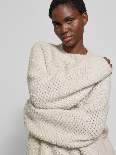 Frauenmodel trägt Pullover mit gerippten Abschlüssen von black palms, Alpaka-Woll-Mix, oversized, Rundhalsausschnitt, Nahaufnahme Oberkörper.