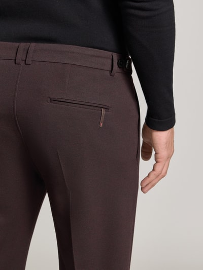 Männermodel trägt Straight Fit Hose mit Viskose-Mix Modell 'Salto' von CINQUE in Dunkelbraun, feines Strukturmuster, Detailaufnahme Rückansicht. Herren Hose, elastischer Material-Mix, Bügelfalten, Haken- und Reißverschluss.